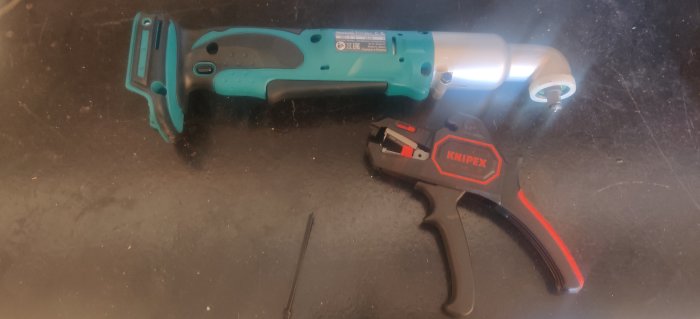 Elverktyg och manuell tång på mörk yta, indikerar nya inköp av verktyg.