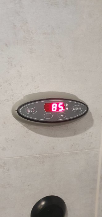 Digital bastu termometer på vägg visar 85 grader Celsius.