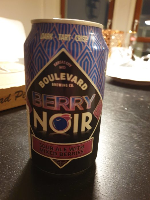 Burk med Boulevard Brewing Co. Berry Noir sour ale med blandade bär på bord.