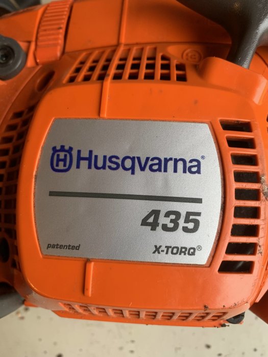 Husqvarna motorsåg modell 435 X-Torq med orange kåpa och märkeslogo.