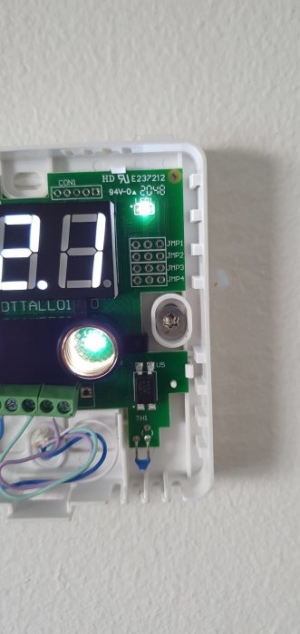 Öppen termostat med synliga jumpers (JMP1-JMP4), digital display och grön lysdiod.