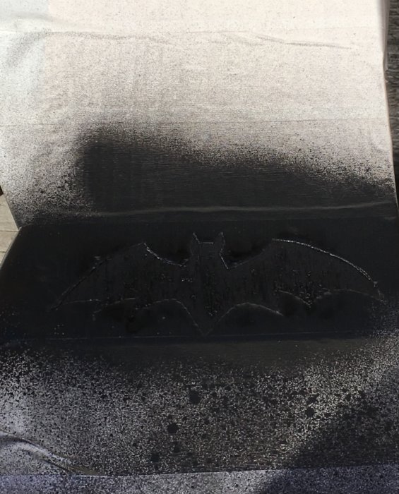 Fläckfri yta med Batman-logotypen synlig där fläckar har avlägsnats.