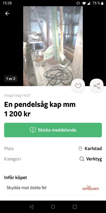 Interiör av en verkstadsbyggnad med en synlig pendelsåg och diverse virke.