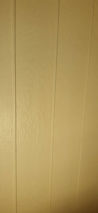Nymålad panel i beige nyans, nästan klart med det sista lagret lackfärg.