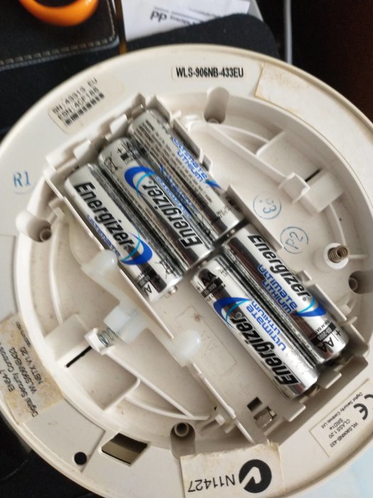 Rökdetektor WLS-906-NB-434 EU öppnad med synliga batterier och insidan.