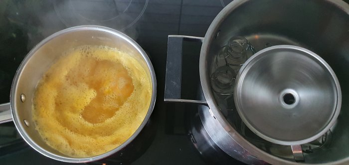 Chili-tillagning med apelsinjuice, ingefära och paprika i kastrull på spis.