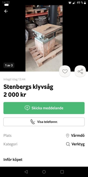 Gammal Stenbergs klyvsåg av gjutjärn på en pall i ett verkstadsutrymme med hyllor och däck i bakgrunden.