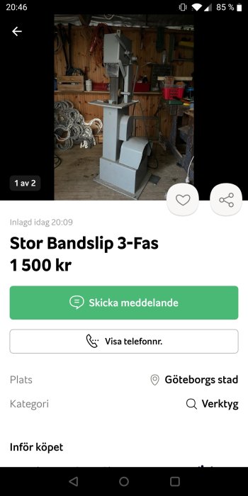 Stor bandslipmaskin i ett verktygsfyllt garage.