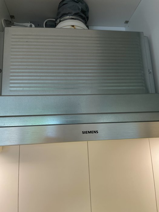 Siemens köksfläkt monterad under skåp utan synliga skruvar.