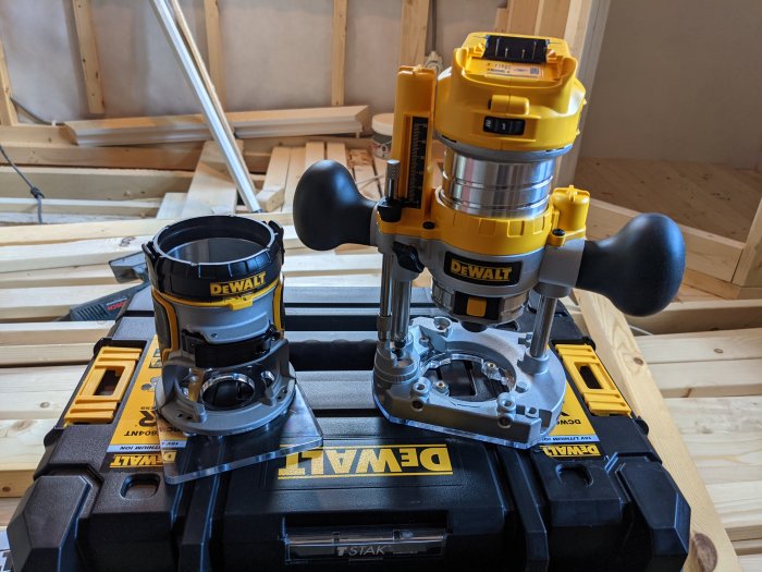 DEWALT fräs placerad på en svart DEWALT verktygslåda med träkonstruktion i bakgrunden.