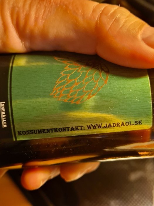 Närbild av en ölflaskas etikett med humlekotte och texten "KOISUMENTKONTAKT: WWW.JADRAOL.SE