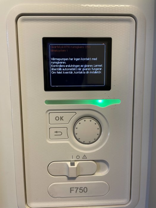 Display på en Nibe 750 frånluftsvärmepump som visar ett felmeddelande om avsaknad kontakt med rumsregulator.