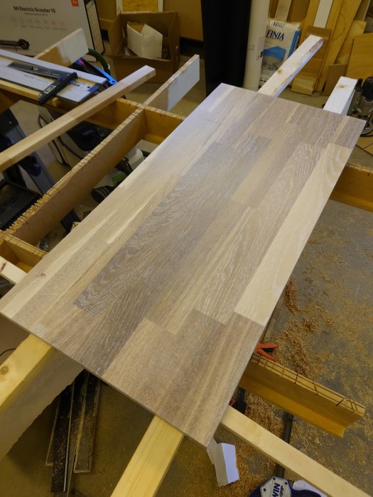 Ett träsideboard i verkstad med första lagret vitpigmenterad oljebets applicerad.