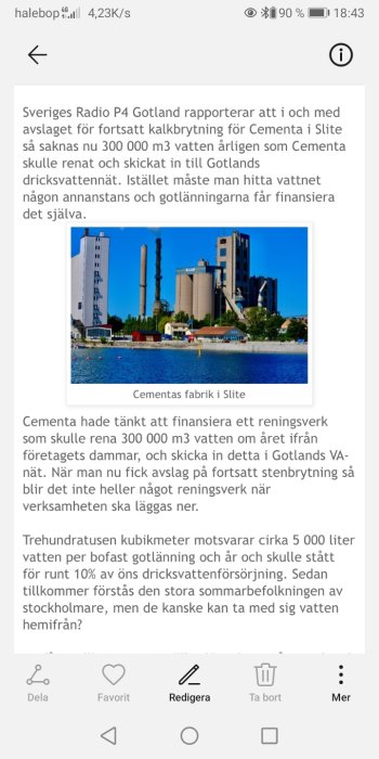 Cementas fabrik vid vattnet i Slite på Gotland under en klarblå himmel.