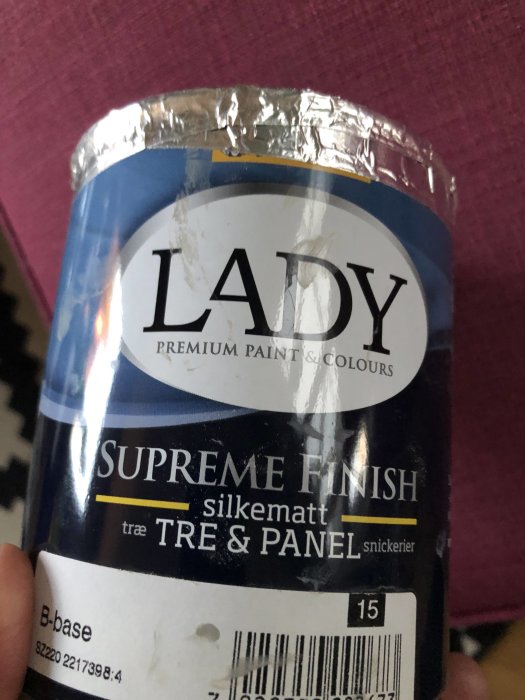 En burk LADY Supreme Finish silkesmatt färg för trä och panel hållen i handen.