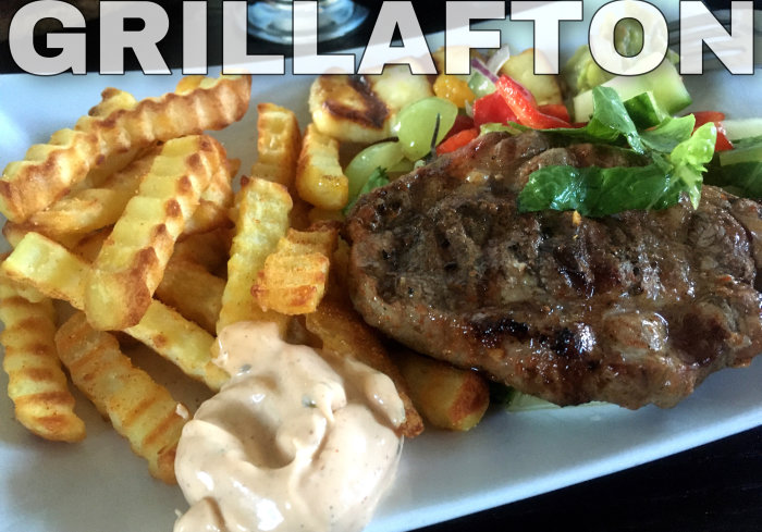 Grilltallrik med fläskkarré, krulliga pommes frites, chilibearnaise, färsk sallad och texten "GRILLAFTON".