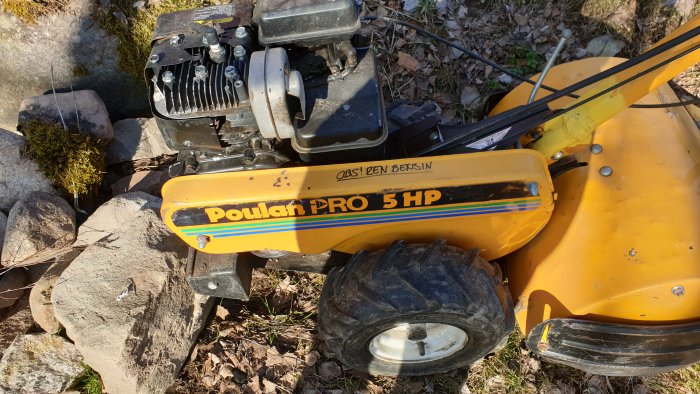 Poulan Pro 5 HP grästrimmer med tydlig text och släppta delar i ett utomhusmiljö.