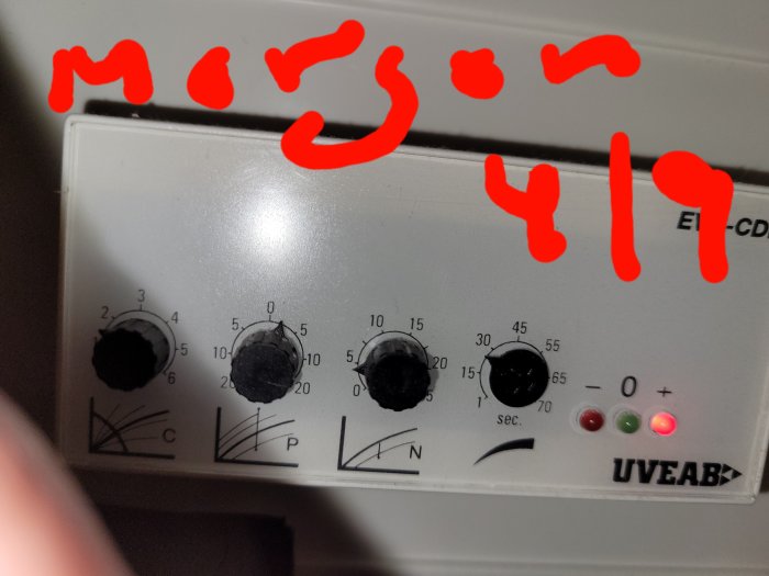 Kontrollpanel för värmesystem märkt UVEAB med inställningsrattar och tre lysdioder, överstruket med röd text "morgon 4/17".