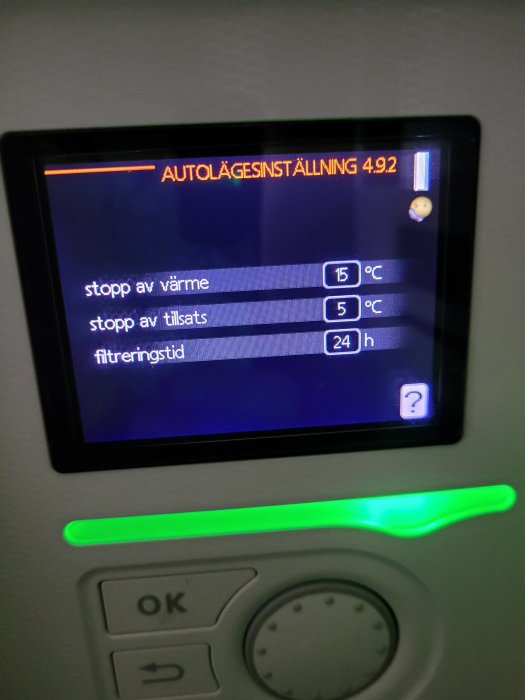 Digital kontrollpanel som visar inställningar för värme och filter med grönt statusljus.