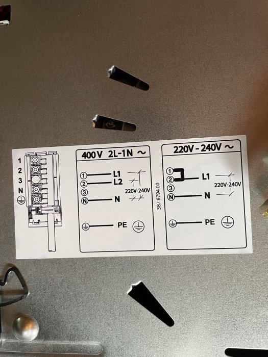 Elkopplingsschema för 220-240V och 400V upplagt på en metalldisk.