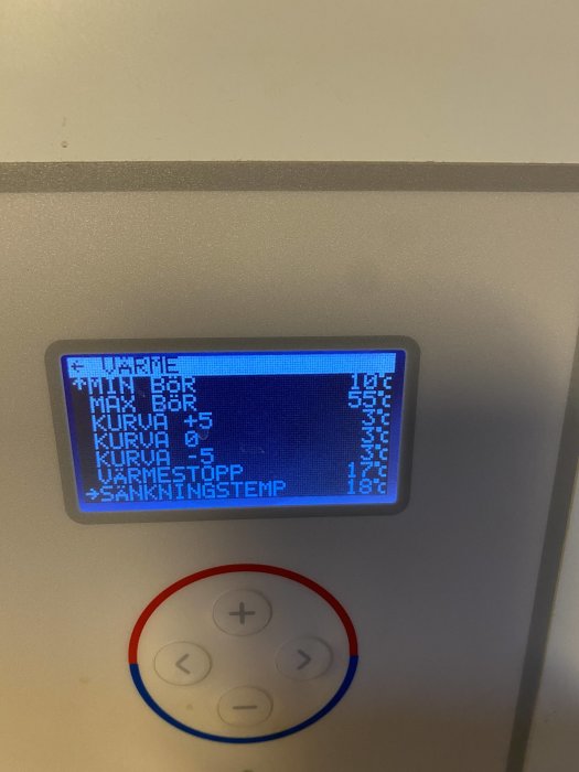 Display på en värmepumps kontrollpanel som visar temperaturinställningar och statusindikatorer.