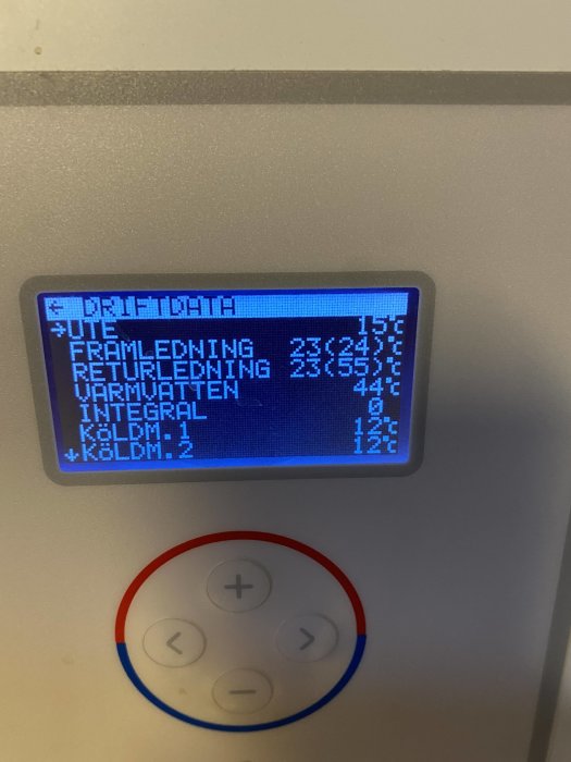 Display på värmepump med text "DRIFTDATA" och temperaturinställningar, omgiven av reglageknappar.