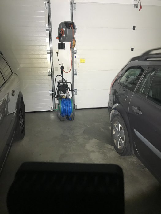 Garageinteriör med bilar, elverktyg på väggen och en självgjord LED-belysning.