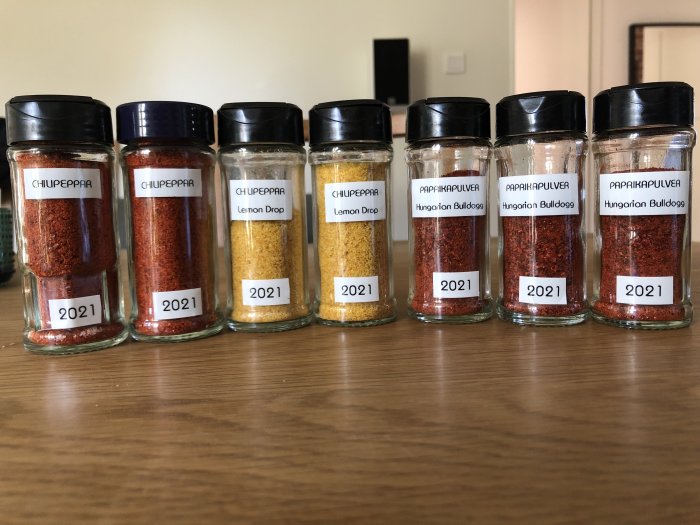 Åtta kryddburkar med hemtorkad paprika och chili märkta "2021", vissa felstavade som "Hungarion Bulldogg".