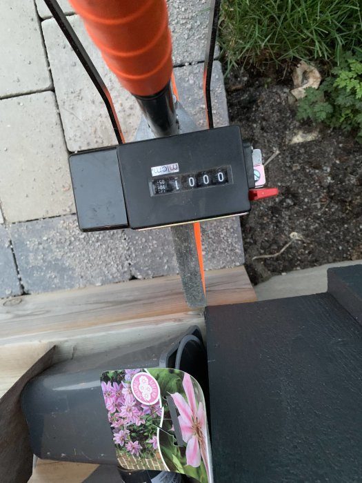 Mätverktyg visar 1000 på displayen med orange sicksacklinje och blommiga etiketter i bakgrund.