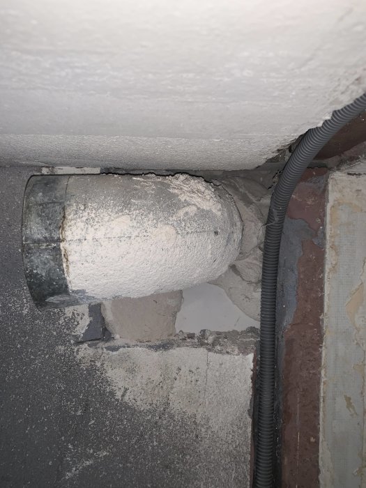 Ventilationsböj i betongvägg med avlägsnat spiralrör i ett renoveringsprojekt.