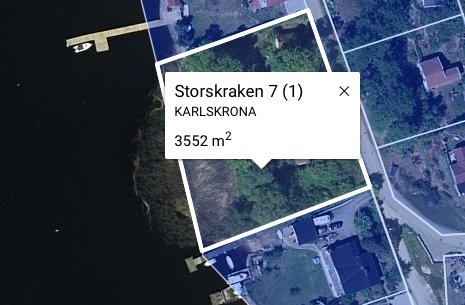 Satellitbild över fastigheten Storskärken 7 i Karlskrona före rivning, med grön omgivning.