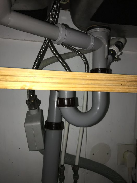 Rörsystem under diskbänk visande kopplingar och slangen från gammal diskmaskin.