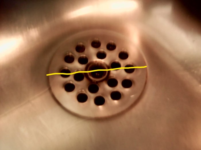 Slätbottnad köksvask med mätsticka över avloppet som visar diameter på cirka 60 mm.