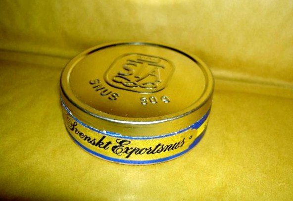 Gammal plåtlock på snusdosa med texten "Svenskt Exportsnus", använd för att justera tändstift.