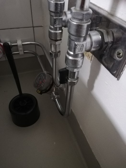 Avstängningsventil och balofixventil vid toalett, sammankopplade med handfatets vattenledning.