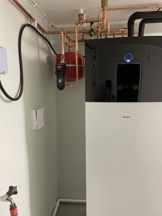 Installation av BoilerMag Magnetfilter på kopparledningar med bakgrund av värmepump och expansionskärl.