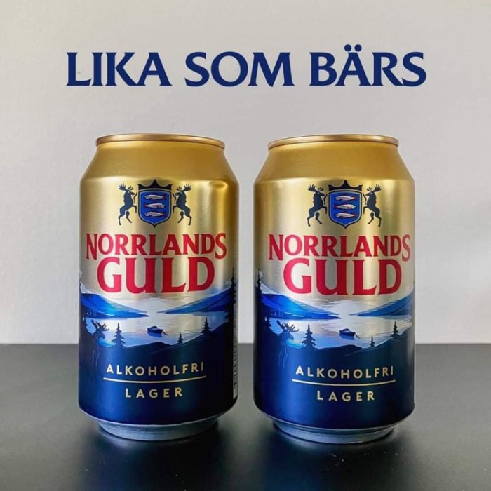 Två burkar Norrlands Guld alkoholfri lager på ett bord, texten "LIKA SOM BÄRS" ovanför.