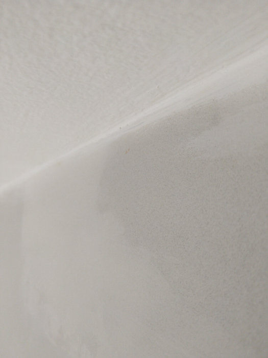 En nymålad vit takyta möter en bredspacklad vägg utan synliga skador.