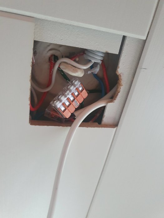 Öppen takdosa med ihopkopplade elektriska kablar och clips av WAGO, utan skyddande låda.