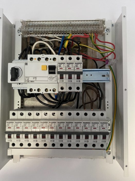 Elcentral med säkringar och kablar inklusive en röd jordkabel.