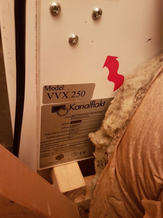 En smutsig värmeväxlare från ett FTX-ventilationsaggregat märkt "VVX 250" med en anvisningsetikett.