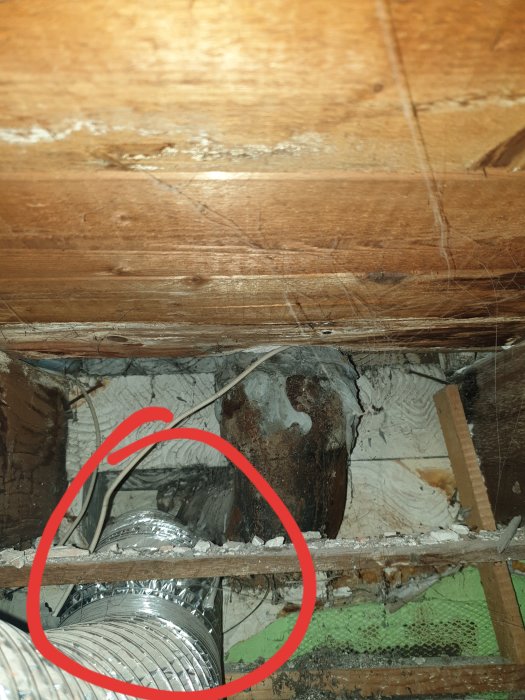 Lös ventilationslang i taket markerad med röd cirkel under badrumsrenovering.