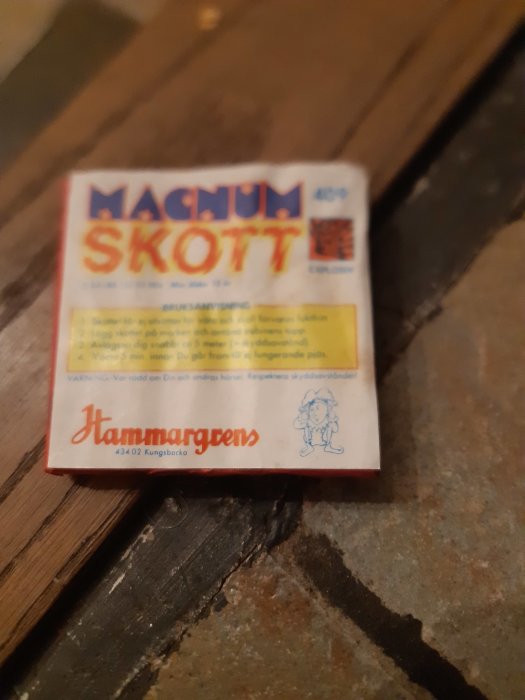 En gammal förpackning av Magnum Skott smällare på ett träbord.