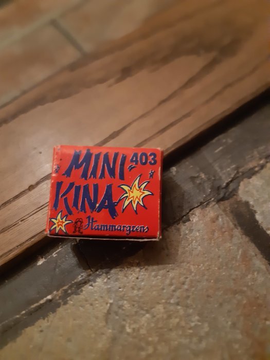 En MINI 403 KINA-smällare på ett trägolv.