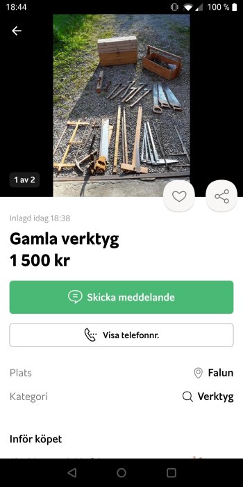 Gamla verktyg, inklusive PIO 310 ryggsåg, utspridda på grus med trälådor i bakgrunden.