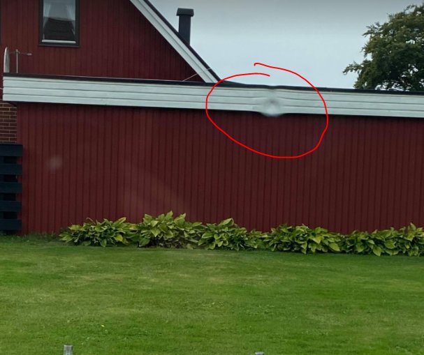 Rött hus med nytt fönster där en spricka syns på det mittersta glaset.