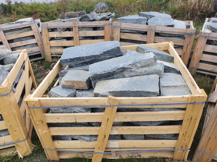 Större stenar levererade i träpallar för byggprojekt.