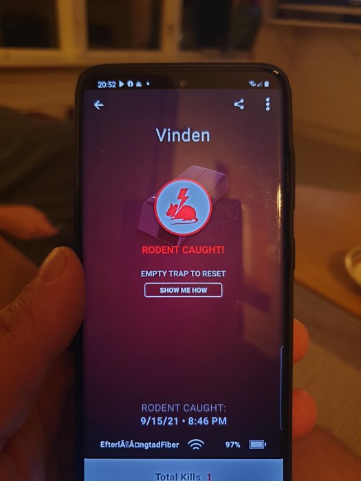 Smartphone som visar appen med meddelandet "RODENT CAUGHT!" och tiden för fångsten.