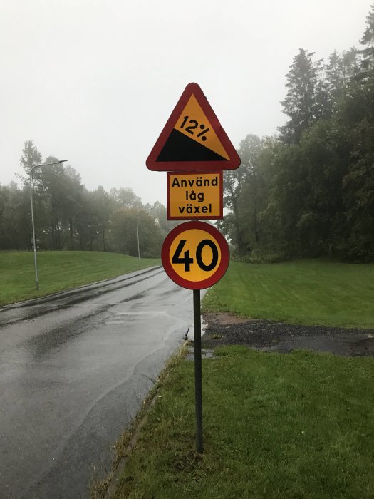 Vägskylt som visar en 12-procentig lutning med anvisningen "Använd låg växel" och hastighetsbegränsning på 40 km/h.