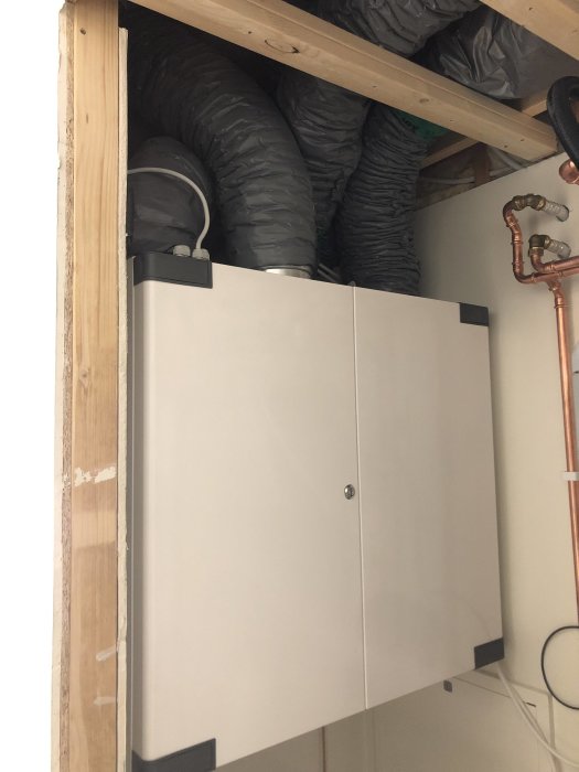 FTX-aggregat installerat i teknikrum med anslutna ventilationsrör och kopparledningar.